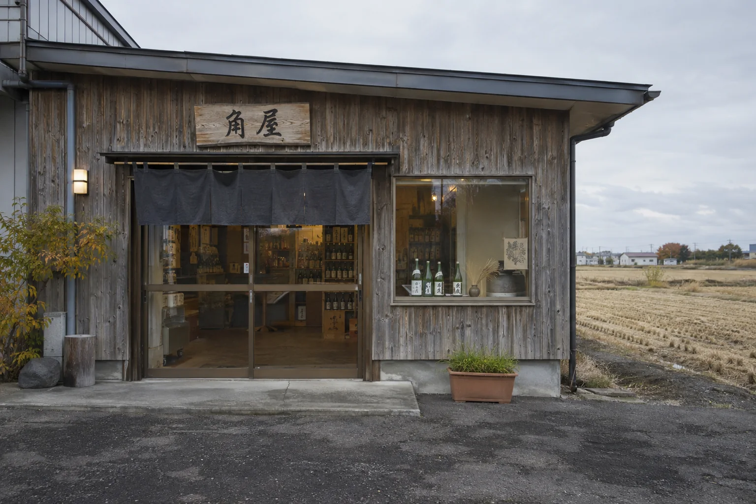 木の看板と小さなのれんが掛かった角屋の外観
